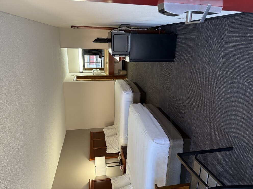 a room with two beds and a small television