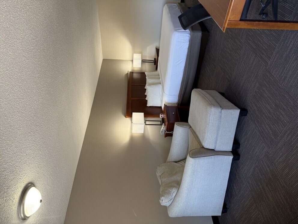 a room with two beds and a chair