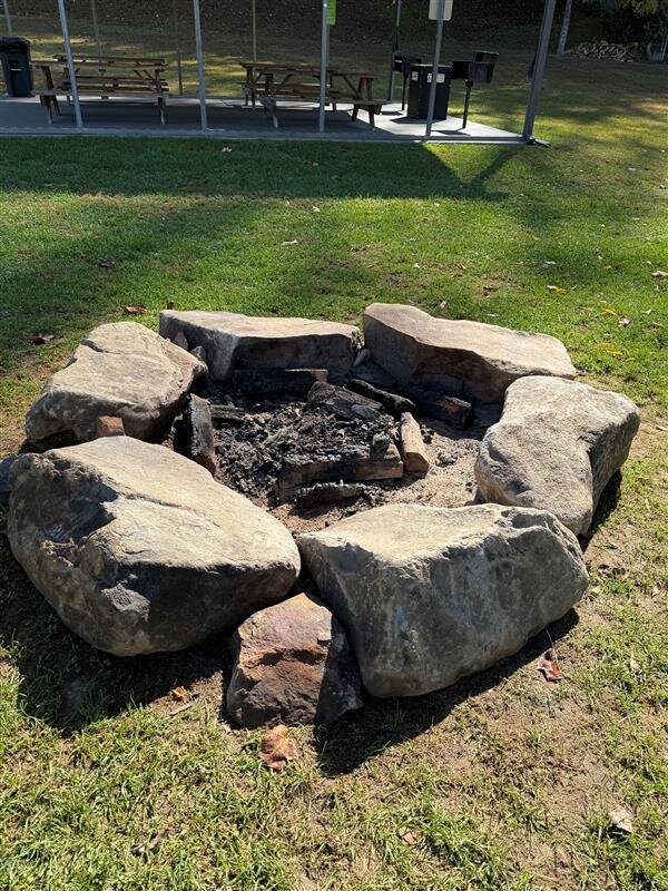 a fire pit in a grassy area